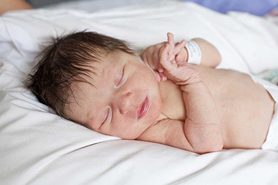 A newborn baby with its eyes closed.