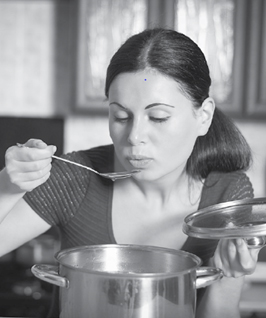 Woman tasting soup.
