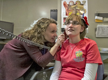 Dr. King, left, performs an otoscopic exam on a clinical trial participant in the audiology clinic.